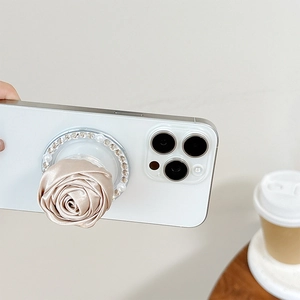 Detail of champagne fabric camellia phone grip with rhinestone and pearl edge