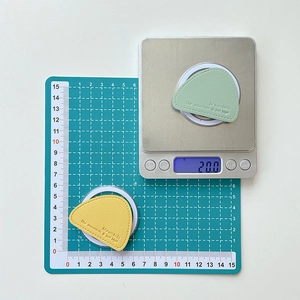 Macro detail of triangle leather magnetic phone stand showing precise size and 20g weight