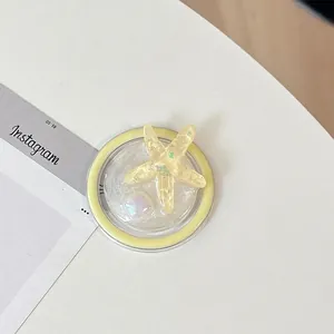 Detail of yellow starfish phone socket with sparkling resin inlay on white surface