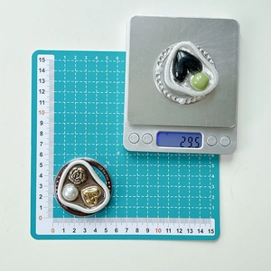 Macro shot of jeweled heart phone grips showing size and weight on a digital scale
