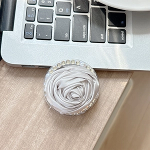 Close-up of a satin camellia phone grip with sparkling rhinestones and pearls decoration