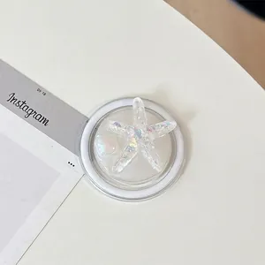 Detailed close-up of a glittery starfish phone grip with a pearlescent bead detail