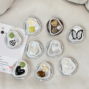 Nine luxury rhinestone phone grips featuring pearls, butterflies, and hearts on beige texture