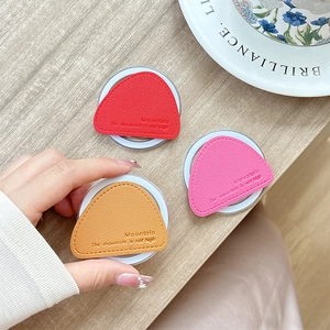 Magnetic leather triangle phone grip holder in red, pink and orange on wooden background