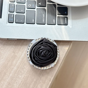 Detailed close-up of a black fabric camellia phone socket with crystal rhinestones