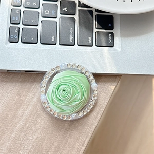 Detailed view of mint green fabric camellia phone socket with rhinestones and pearls