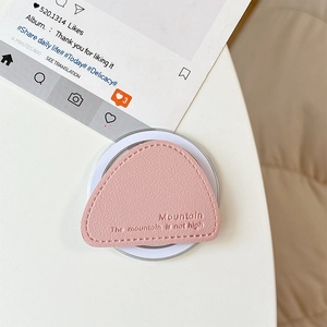 Detailed shot of pink leather triangle phone socket with embossed mountain quote texture
