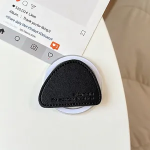Close-up of black leather magnetic triangle phone grip with textured litchi grain and stitching