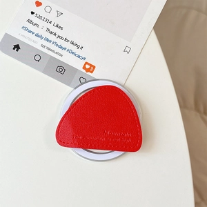 Detail of red leather triangular magnetic phone grip with fine stitching and embossed text