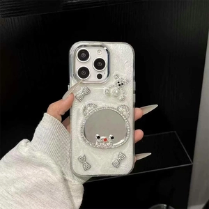 Close-up of glitter iPhone case featuring 3D pearl bear, diamond bow, and mirror detail