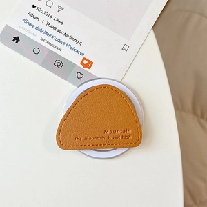 Macro detail of brown leather magnetic phone socket with lychee grain and mountain embossed