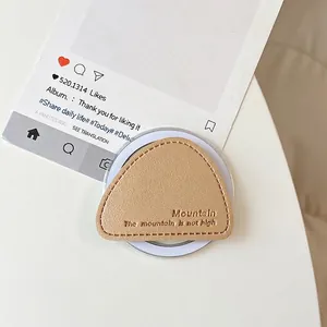 Close-up of tan leather triangle magnetic phone grip with mountain embossed texture