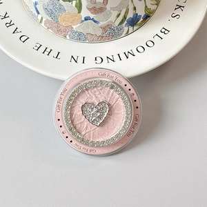 Detailed macro view of pink leather phone grip with a sparkling diamond heart center