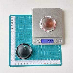 Detail view of heart-shaped phone grip showing 5.5cm width and 35.5g weight on scale