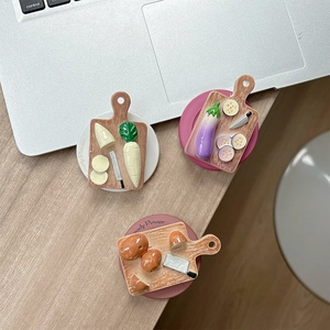 Miniature resin eggplant and radish on wooden cutting board phone grip and stand