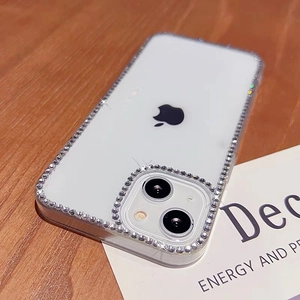 Close-up of clear iPhone case featuring luxury rhinestone borders and camera ring detail