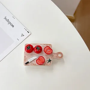 Detail shot of mini cutting board with tomato models and small knife phone grip