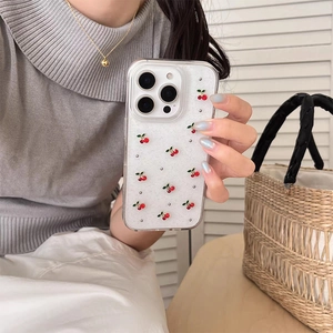 Detail of transparent glitter iPhone case with 3D cherry patterns and silver studs