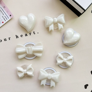 7-piece white pearlescent bow and heart phone sockets set on beige leather background