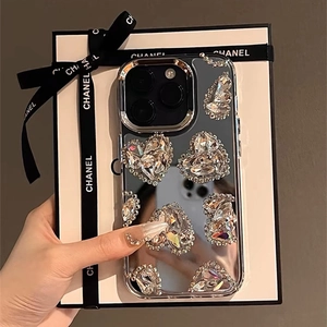 Detailed macro view of luxury rhinestone heart mirror phone case with elegant gift box