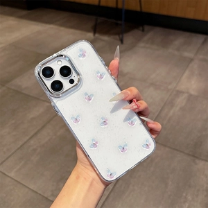 Détail d'une coque iPhone transparente avec papillons 3D et paillettes tenue en main