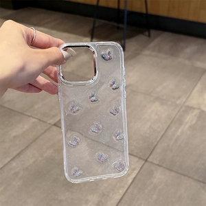 Détail d'une coque iPhone avec papillons 3D arc-en-ciel et paillettes tenue en main