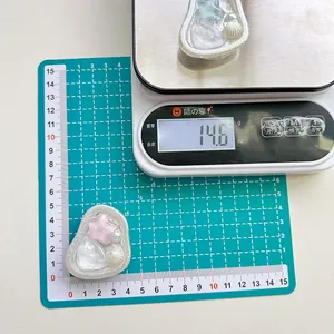 Dettaglio del supporto per telefono con perle e stella che mostra il peso di 14,6g