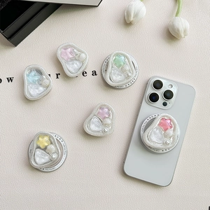 Supporto per telefono a stella con perle e conchiglie su sfondo in pelle