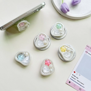 Dettaglio del supporto Griptok in resina colorata con perle e stelle su smartphone