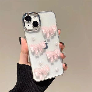 Nahaufnahme der glitzernden iPhone-Hülle mit rosa Schleifen und weißen Perlenakzenten