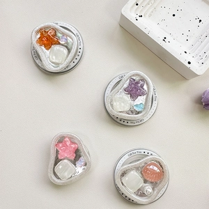 Set of four shell and heart griptoks with pearl accents on a white textured background