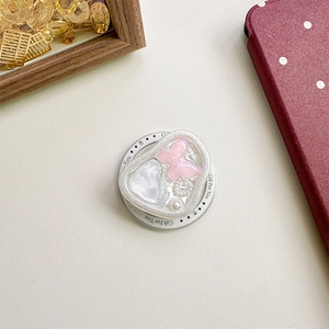 Detail view of heart-shaped resin phone grip with pink butterfly and pearl accents