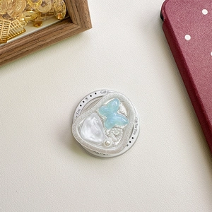 Detailed view of heart-shaped phone grip with blue butterfly and pearl decorations