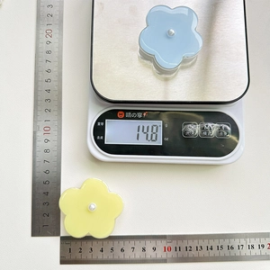 Detailed view of flower phone grip weight and size showing 14.8g on scale