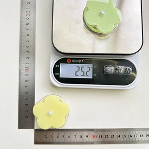 Macro shot of two floral phone grips showing 4.5cm diameter size and 25.2g weight
