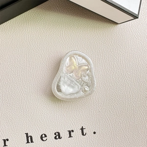 Detail of pink glitter butterfly and white gemstone on resin phone socket mount
