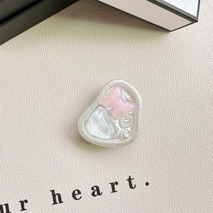 Macro shot of pink glitter butterfly phone grip with pearl and shell accents