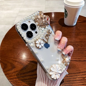 Elegant iPhone 16 Pro Max clear case with white pearls, gold crown, and floral accents