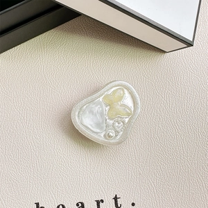 Detail of Korean style resin phone grip with butterfly, heart, and pearl inlay detail
