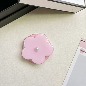 Detailed view of pink flower phone socket with a pearl center on a beige texture