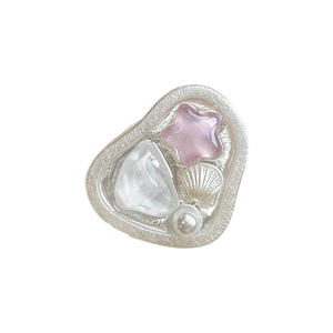 Supporto per telefono a tema marino con stella rosa, conchiglia e perla su bianco