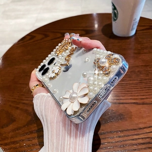 Detail of iPhone case with white pearls, golden flowers and Love lettering accents