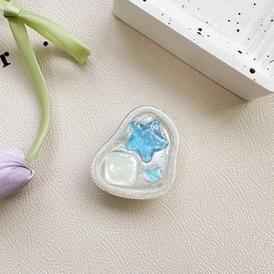 Macro detail of heart and star resin charms inside a translucent blue phone grip