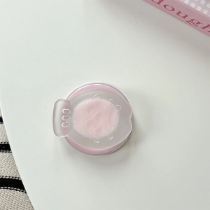 Close-up of pink retractable phone grip with cute embossed face on white desk