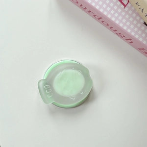 Close-up of a light green translucent matte round phone grip with minimalist 000 design
