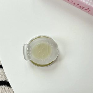 Detail of cute fish-shaped phone stand with translucent lid and cream-colored texture