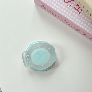 Top view of a mint green round phone grip with a cute cartoon animal embossed on the cover