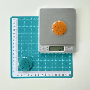 Detail of round resin phone socket grips showing orange and green black speckled texture