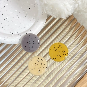 Minimalist round phone grip with artistic black spots on translucent colorful resin