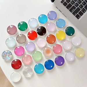 Colorful crystal glass round telescopic phone grip stands displayed on office desk